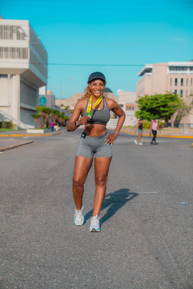 Belinda Williams, investor relations manager at National Commercial Bank, shows off her medal after completing the course during her training for the upcoming Reggae Marathon.