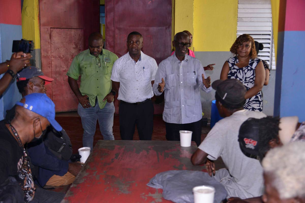 Desmond McKenzie (standing, second right), minister of local government and community development, addresses members of the homeless community while looking on (from left) are Xavier Chevannes, chief engineering officer in the Kingston and St Andrew Munici