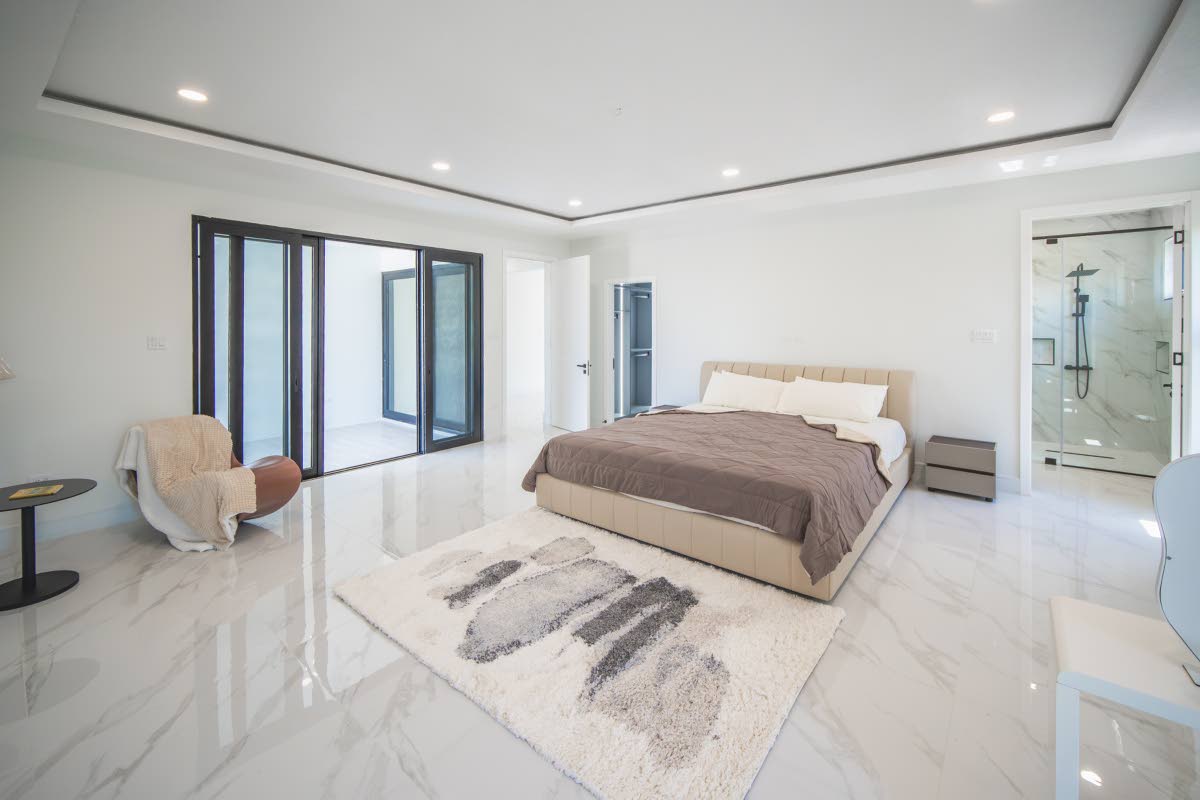 A spacious bedroom with a walk-in closet and a sea view balcony.