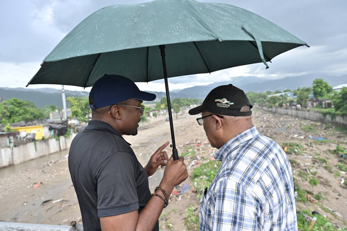 Robert Morgan (left), minister without portfolio with responsibility for works, speaks with Anthony Hylton, member of parliament for St Andrew Western during a pre-tropical storm tour of the cleaning of Sandy Gully and other key areas where preventative me