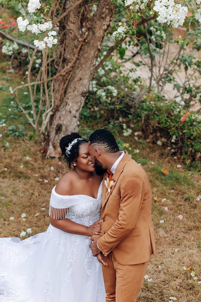 Basking in unforgettable nuptial bliss, the married couple lean in to share a kiss.