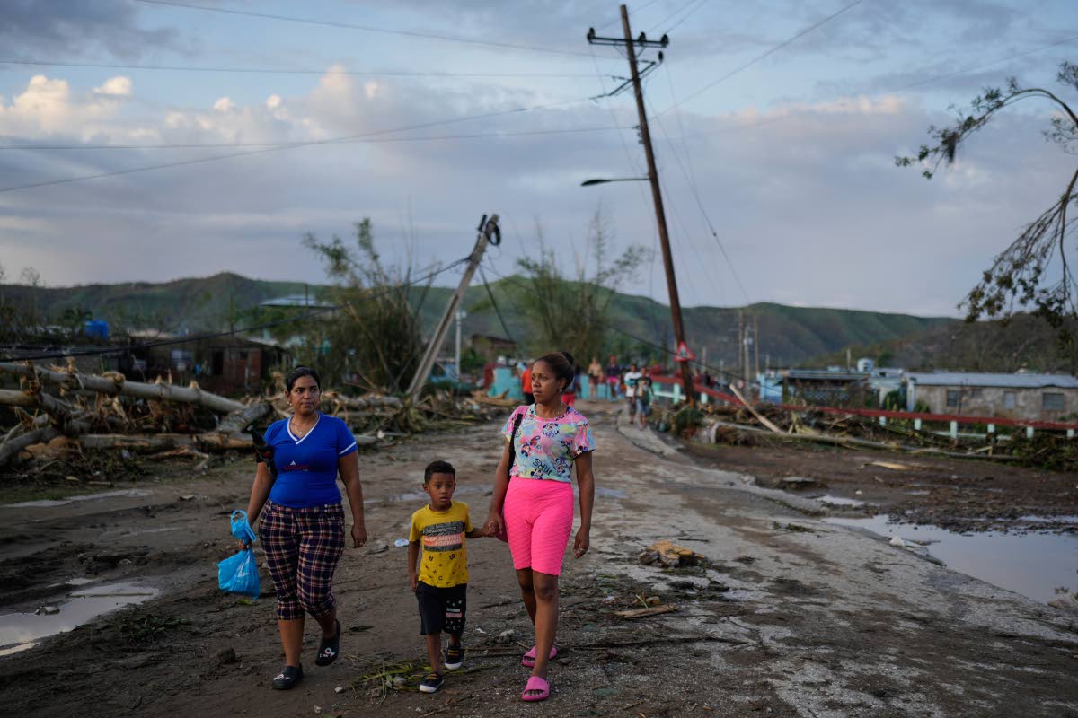 Residents walk in the aftermath of Hurricane Melissa in El Cobre, Cuba, Wednesday, October 29, 2025. (AP Photo/Ramon Espinosa)