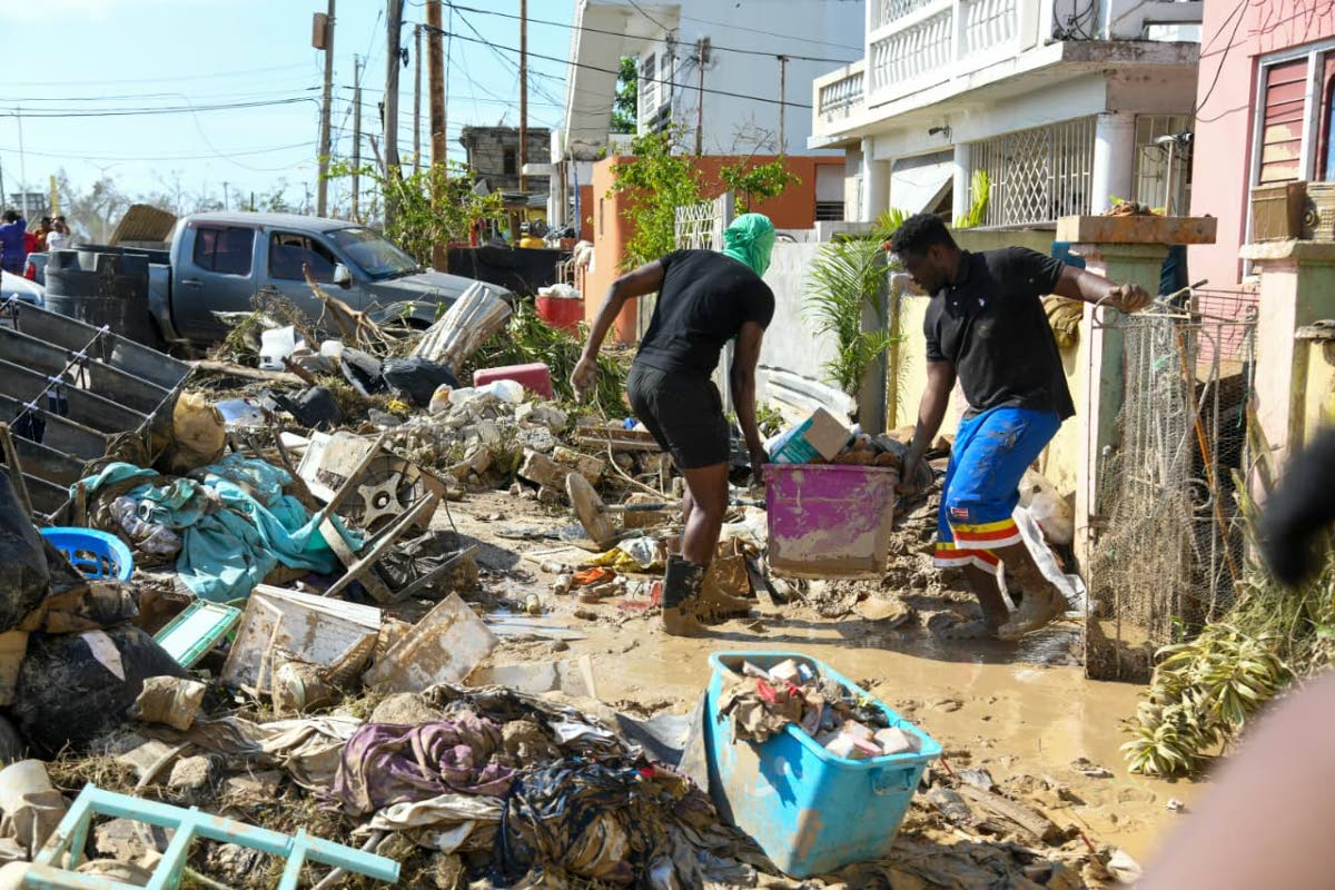 Residents work overtime to clear mud from a home in Catherine Hall, St James.