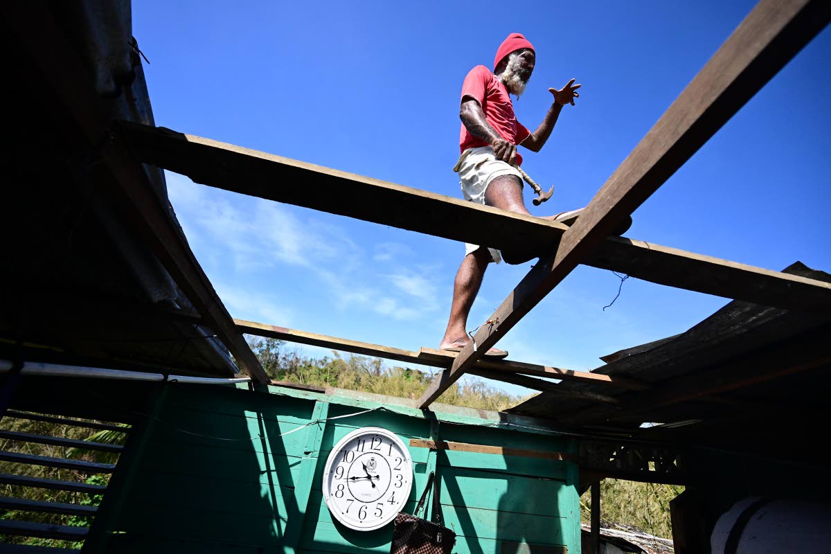 Rohan Getten makes quick repairs to his damaged roof in Green lsland, Hanover. Getten pleads for much-needed help, not just for himself but for others who are unable to help themselves.