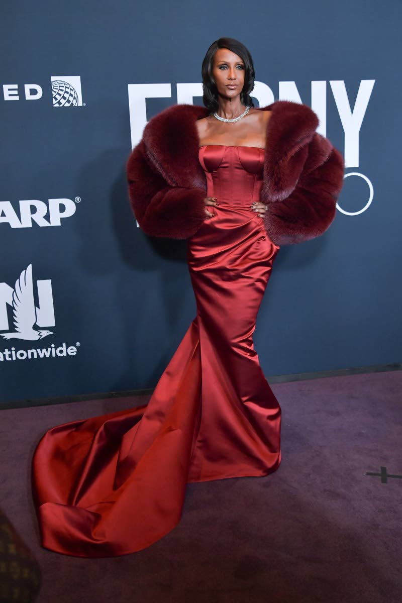 Icon of the Year awardee Iman wears a deep red satin gown, paired with a burgundy stole. 