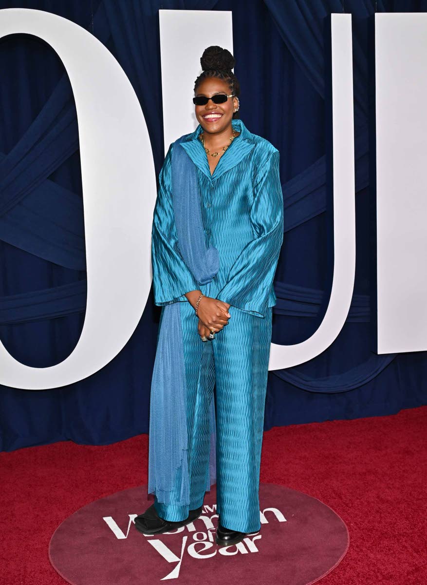 Honouree Jonquel Jones wears a teal suit and draped scarf.