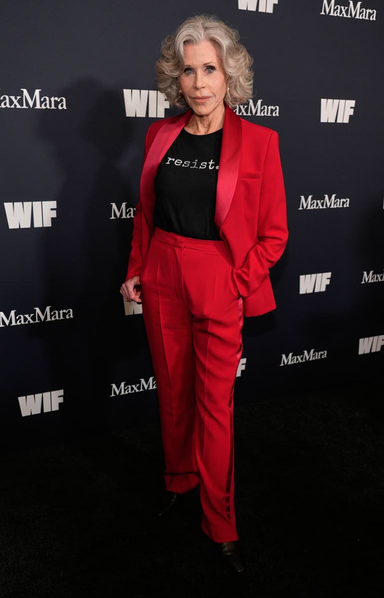 Jane Fonda resists conventions, pairing her red suit with a resistance T-shirt. 