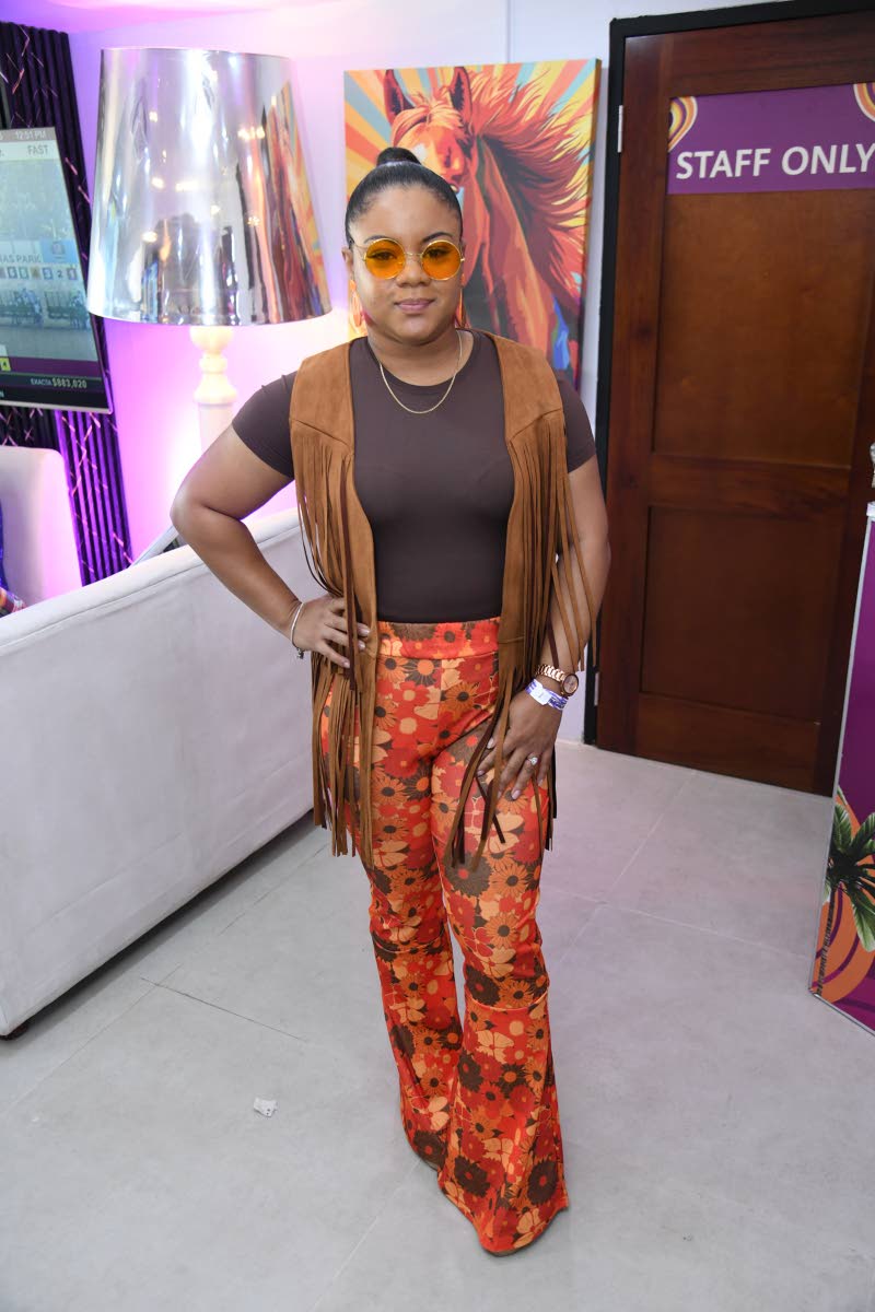 Candace Thomas, media relations officer at the Jamaica Tourist Board, is a picture of retro perfection in earth tones, floral print, bell-bottom pants, and a fringe hippie vest.