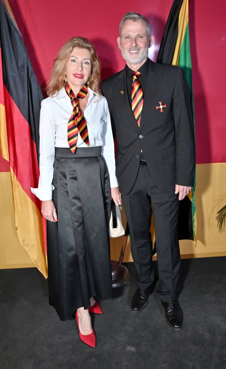 Jan Hendrik van Thiel, German ambassador to Jamaica, and his wife Marina Siniavskaia pull together their outfits with a German flag-colour scarf and tie.