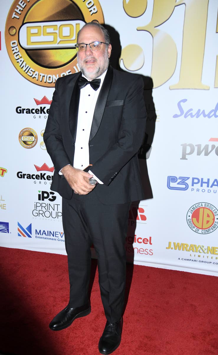 Opposition Leader Mark Golding arrives at the main event suited in classic black and white. 