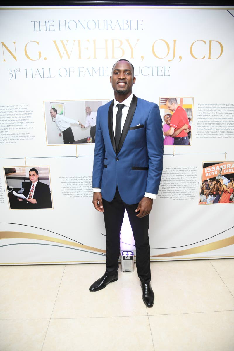 Olympic medallist Hansle Parchment is all smiles in this sleek black-and-blue suit.