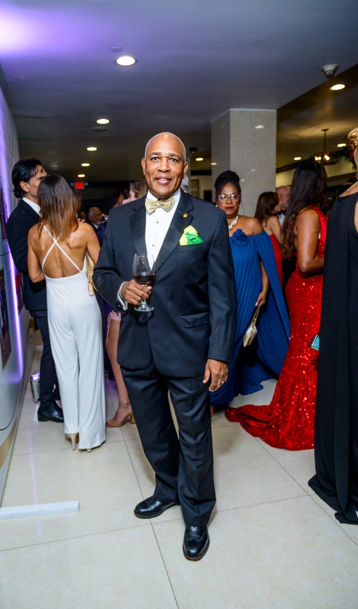 Chris Reckord, CEO of tTech Limited, wearing a classic black tuxedo elevated by a confident pop of green and yellow at the pocket.