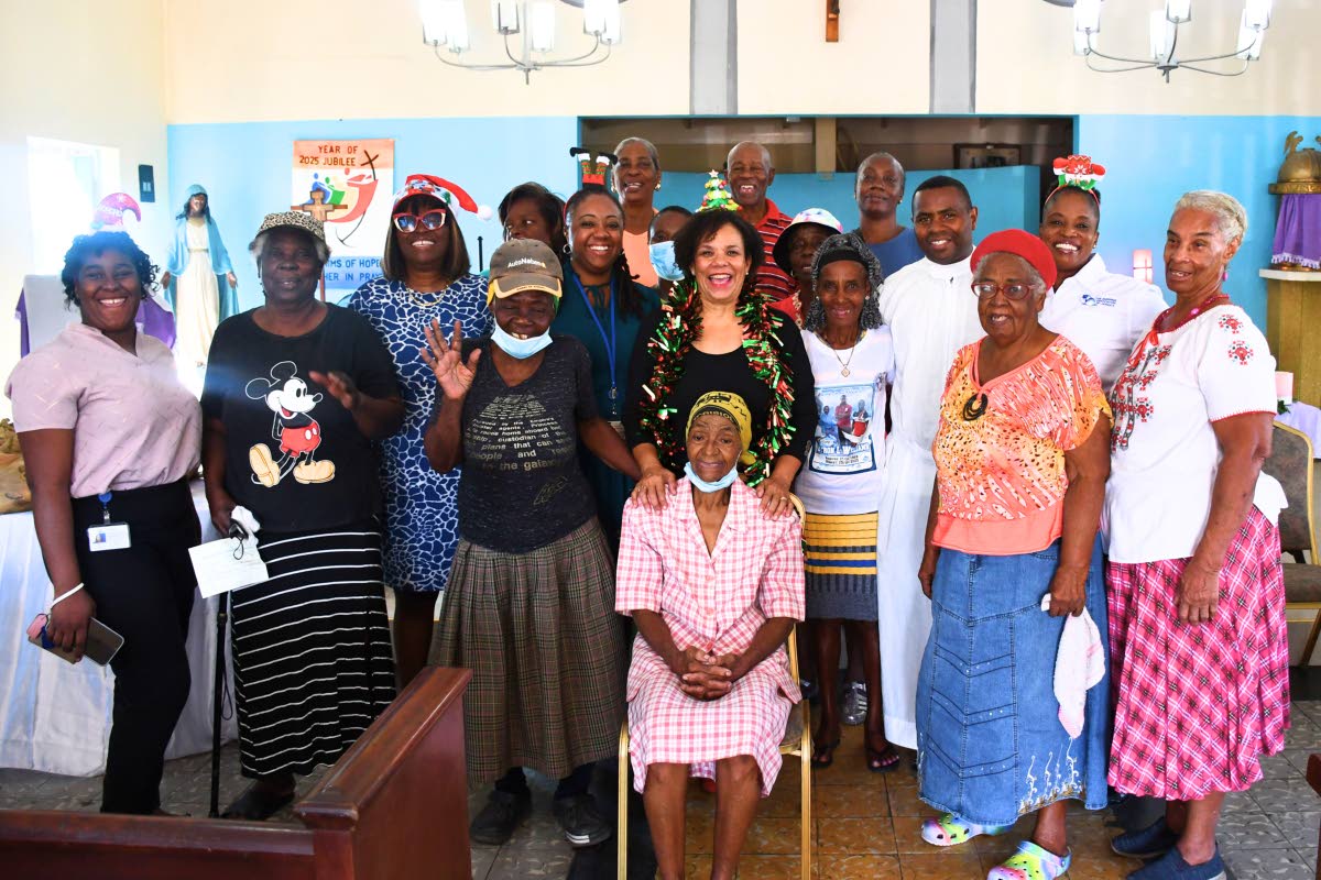 Shipping Association of Jamaica President Corah Ann Robertson‑Sylvester (front row, centre) shares in the annual Christmas treat with elderly residents of the Greenwich Farm community.