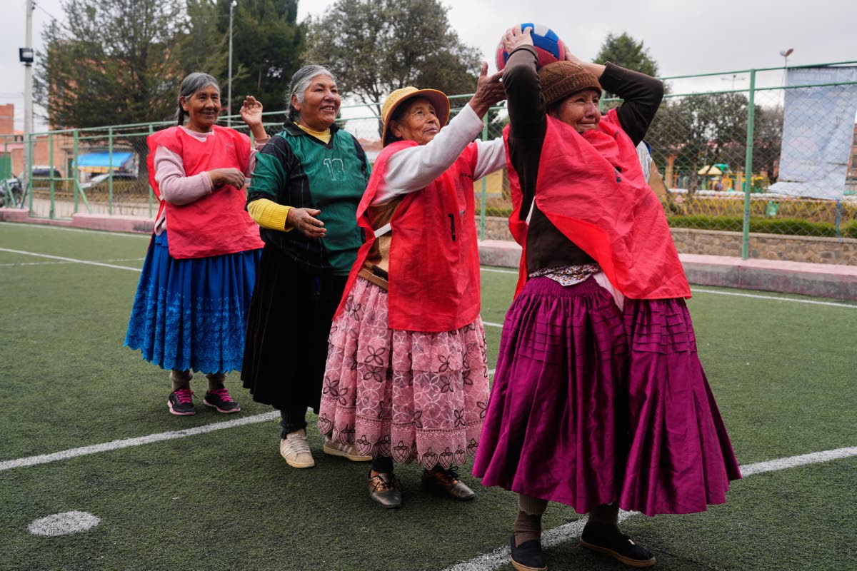 An Aymara grandmother passes the ball during a warm up before the start of a handball match in El Alto, Bolivia.