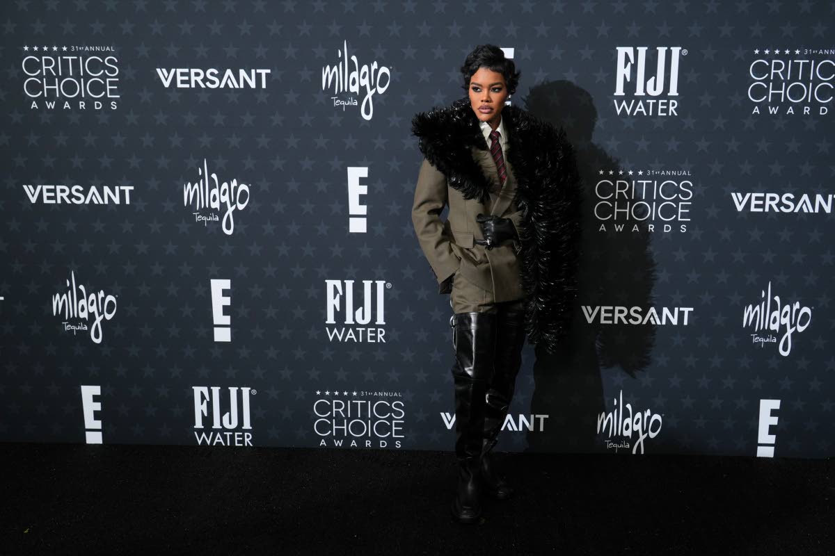 Teyana Taylor wears a Saint Laurent suit and thigh-high boots, paired with a dramatic stole, and Tiffany & Co jewellery. 