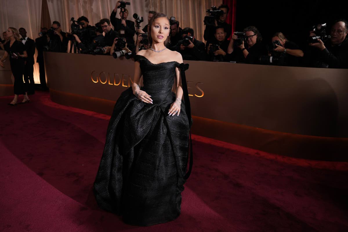 Ariana Grande leaves pink behind for a custom black Vivienne Westwood gown, keeping her iconic ponytail intact.