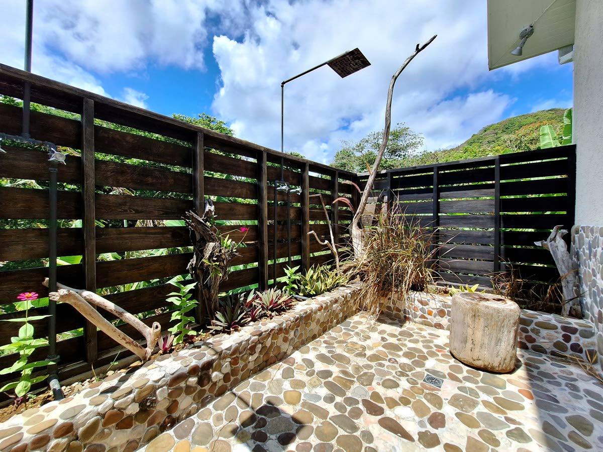 The owner’s suite on the ground floor stuns with an open-air double rain shower set in stone.