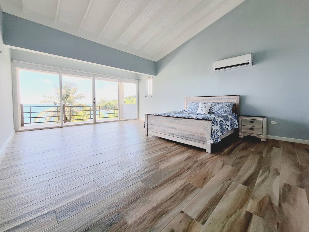 A spacious, minimalistic bedroom with full access to sea views.