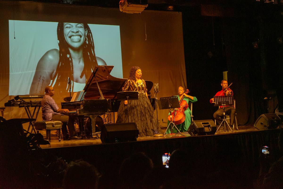 Raehann Bryce-Davis performs alongside musicians Emily Elliott on cello and Jovani Williams on violin.