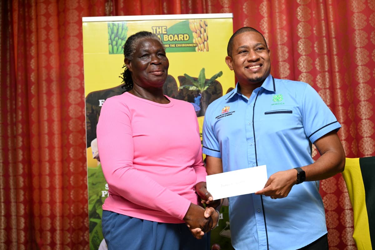 Agriculture Minister Floyd Green presenting Novelette Moore, a St James banana farmer, with her Hurricane Melissa recovery assistance cheque on February 25.