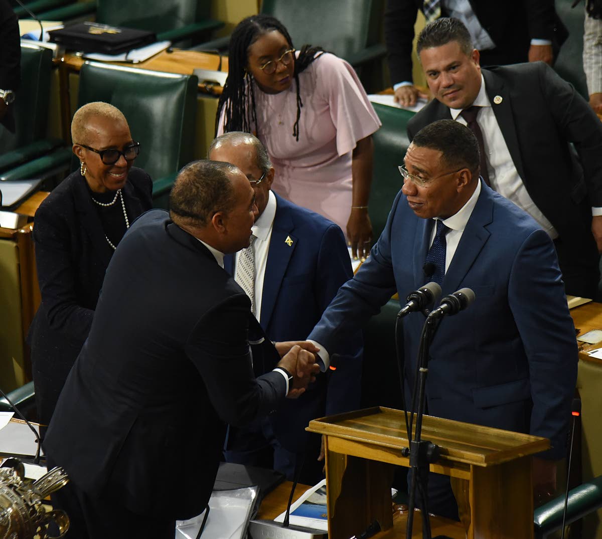 Prime Minister Dr Andrew Holness (right) is congratulated by Government members of the House of Representatives after making his contribution to the 2026-2027 Budget Debate at Gordon House in downtown Kingston yesterday. 