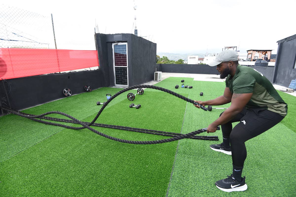 Right: Francis demonstrates the battle rope exercise at the open air fitness area on the roof of his new gym located in Parkington Plaza in St Andrew.