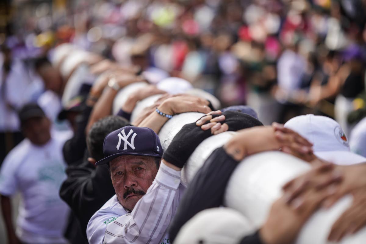 Faithful carry a cross to the Tree of Life during a Good Friday procession in the Ciudad Bolivar neighbourhood of Bogota, Colombia.