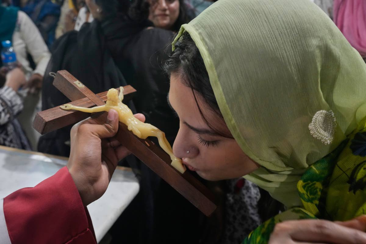 A Christian woman kisses a Jesus Christ cross during Good Friday service at Sacred Heart Cathedral, in Lahore, Pakistan.