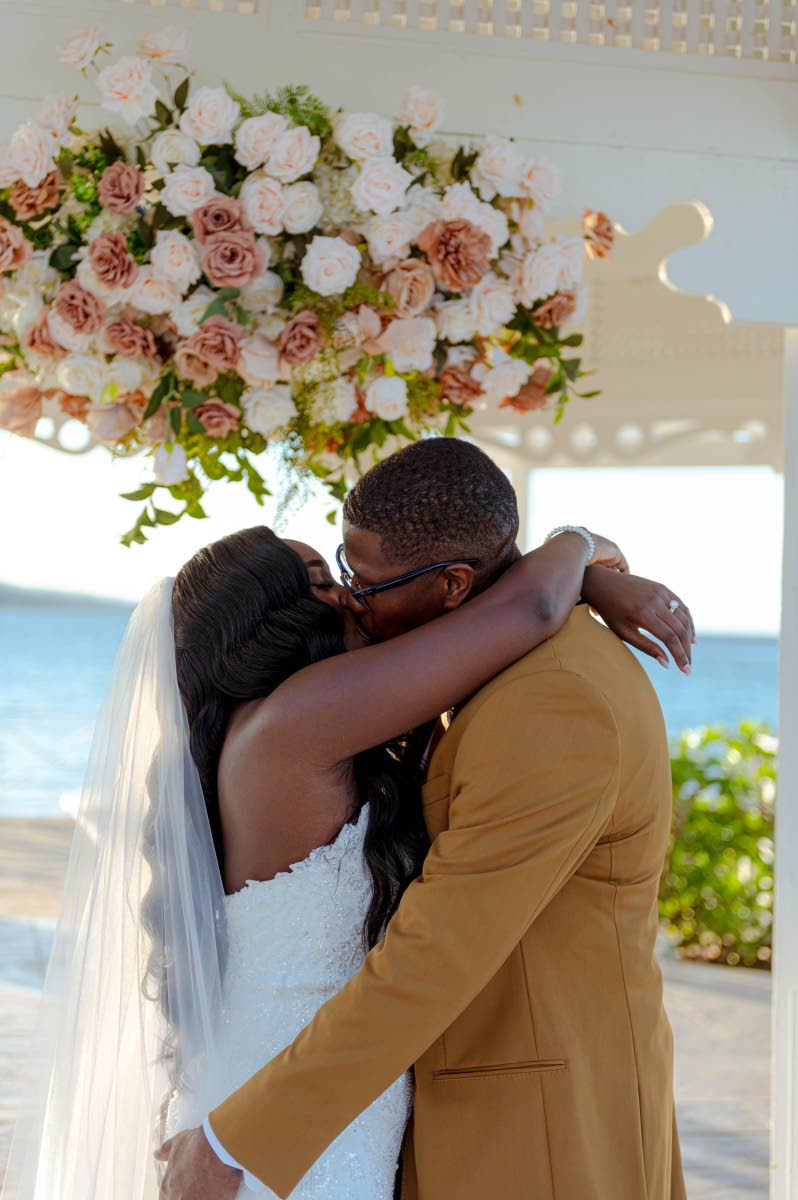 Sealing their vows with a sweet kiss, the newlyweds share their first moment as husband and wife.