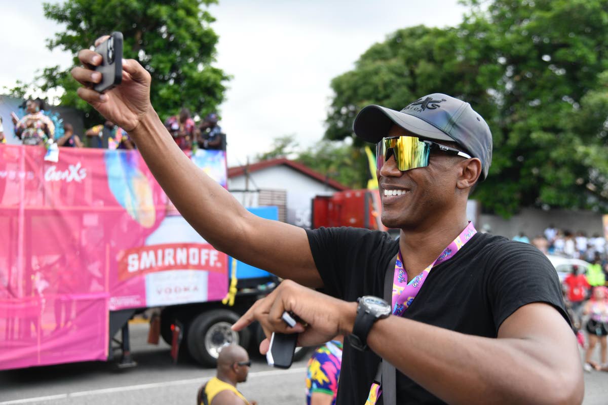 A proud Kibwe McGann, director of Gen XS Carnival, is all smiles as he snaps a video during the crossing of the stage.