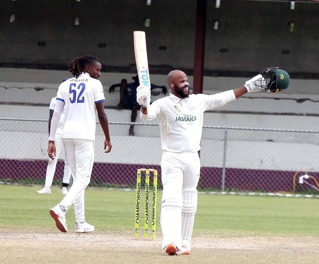 Jamaica Scorpions skipper John Campbell (right) celebrates scoring a century on the fourth day of the West Indies Championship cricket match against Barbados Pride at Chedwin Park, St Catherine, yesterday. Walking away is Barbados Pride paceman, Shamar Spr