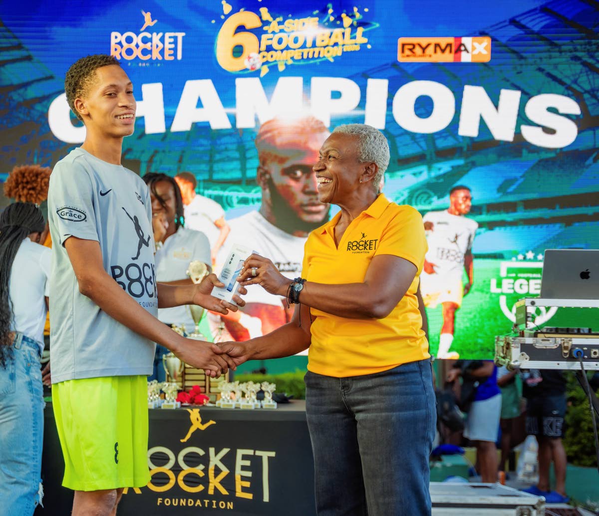 Colleen Montague (right), executive board member of the Pocket Rocket Foundation, presents Jaheim Dorman with his Most Valuable Player award following the Foundation’s Peace Through Sports Six-A-Side Football Competition that ended on March 8.