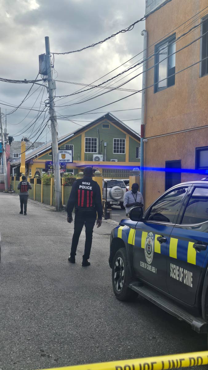 Crime scene officers outside the New Testament Church of God at Water Lane in Montego Bay, St James, yesterday, where a member of the church was shot dead.
