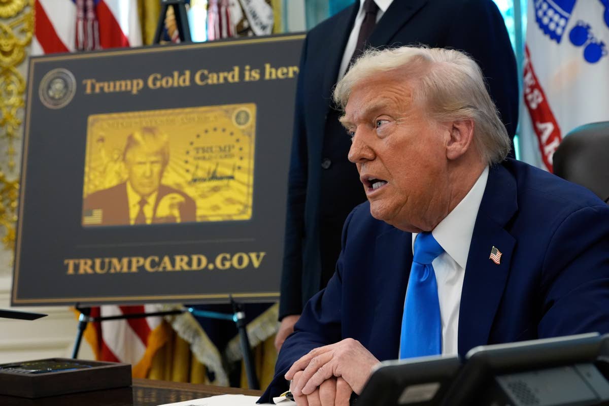 A poster showing the Trump Gold Card is seen as President Donald Trump signs executive orders in the Oval Office of the White House, September 19, 2025, in Washington. (AP Photo/Alex Brandon, File)