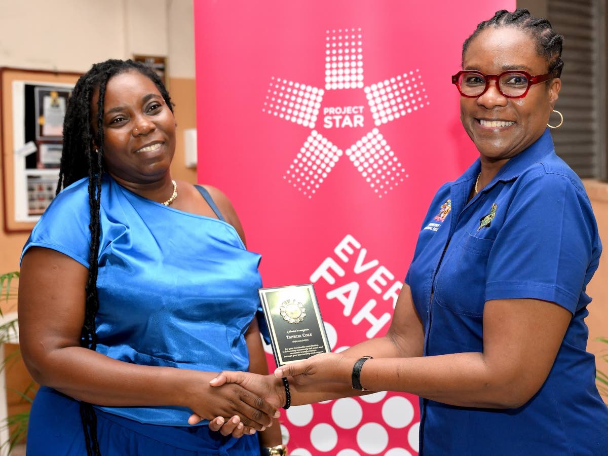 Community champion Tanecia Cole (left) receives her award from Ambassador Alison Stone Roofe, permanent secretary, Ministry of National Security and Peace, at the Project STAR Town Hall, Pentab High School, Kingston recently.