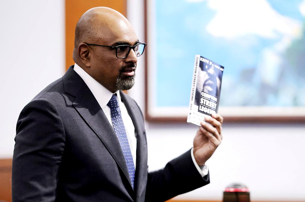 Chief Deputy District Attorney Binu Palal holds a copy of Duane Davis’ book ‘Compton Street Legends’ during closing arguments in the Duane Davis murder trial, related to the 1996 killing of rapper Tupac Shakur, in Clark County District Court at the R