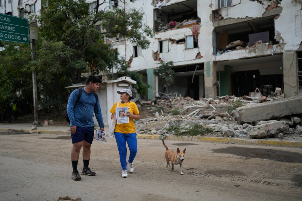 Pedro Gomez (left) walks through La Guaira, Venezuela, with a friend, asking people if they have seen his cousin, Andres Molina.