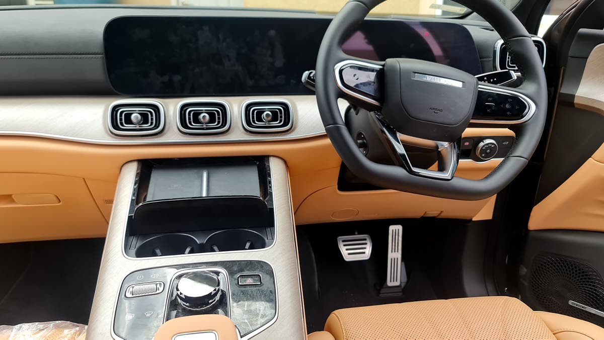 The centre console is anchored by a stunning transparent gear selector that catches the light, surrounded by a minimalist layout that ditches clutter for class.