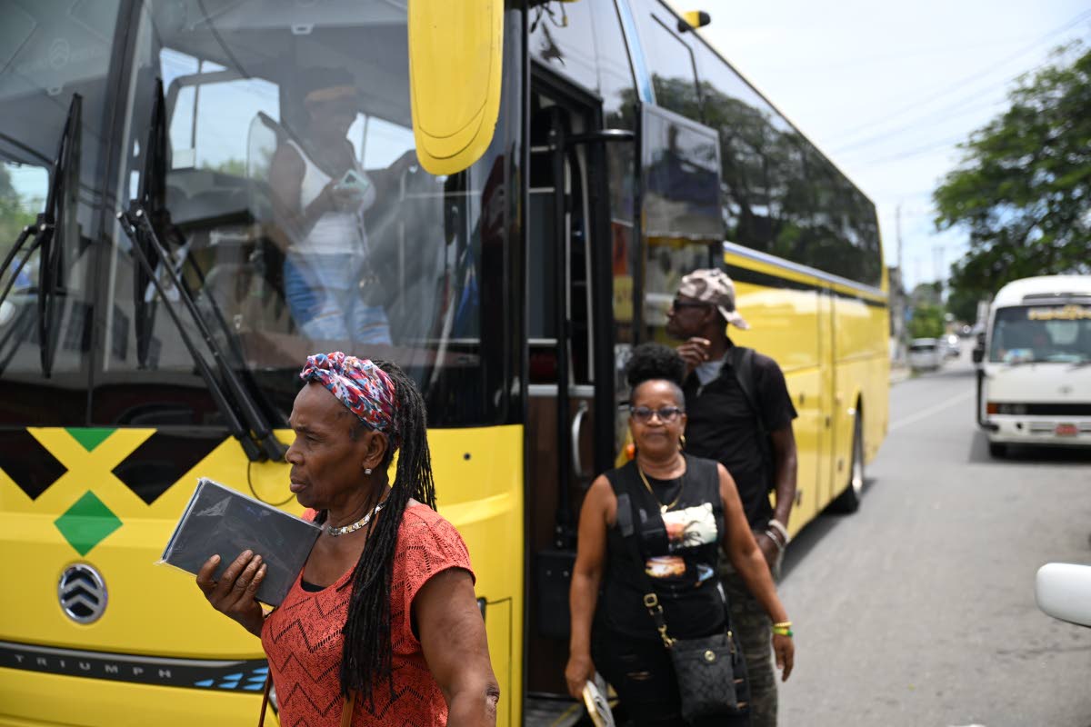 Passengers who boarded the bus in Port Antonio for the official launch of the Jamaica Urban Transit Company’s  Route 710 service disembark in Yallahs Square, St Thomas, on September 23. The service provides scheduled transportation between Port Antonio a