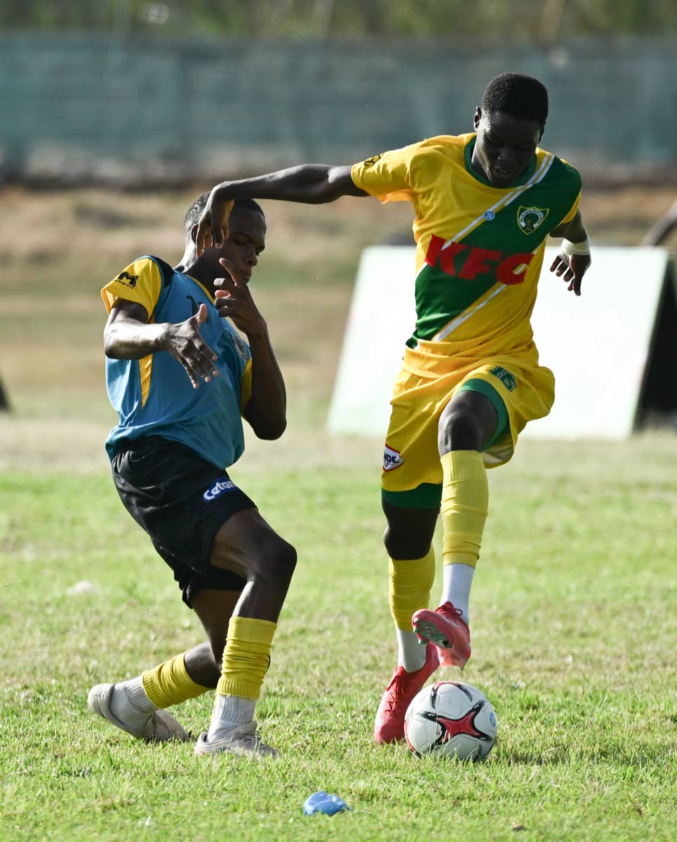 Kingston Technical High School’s Richard West (left) tries to get close to Excelsior High School’s Aldeano Walters during their Walker Cup football encounter at Excelsior High’s playing field on September 26.
