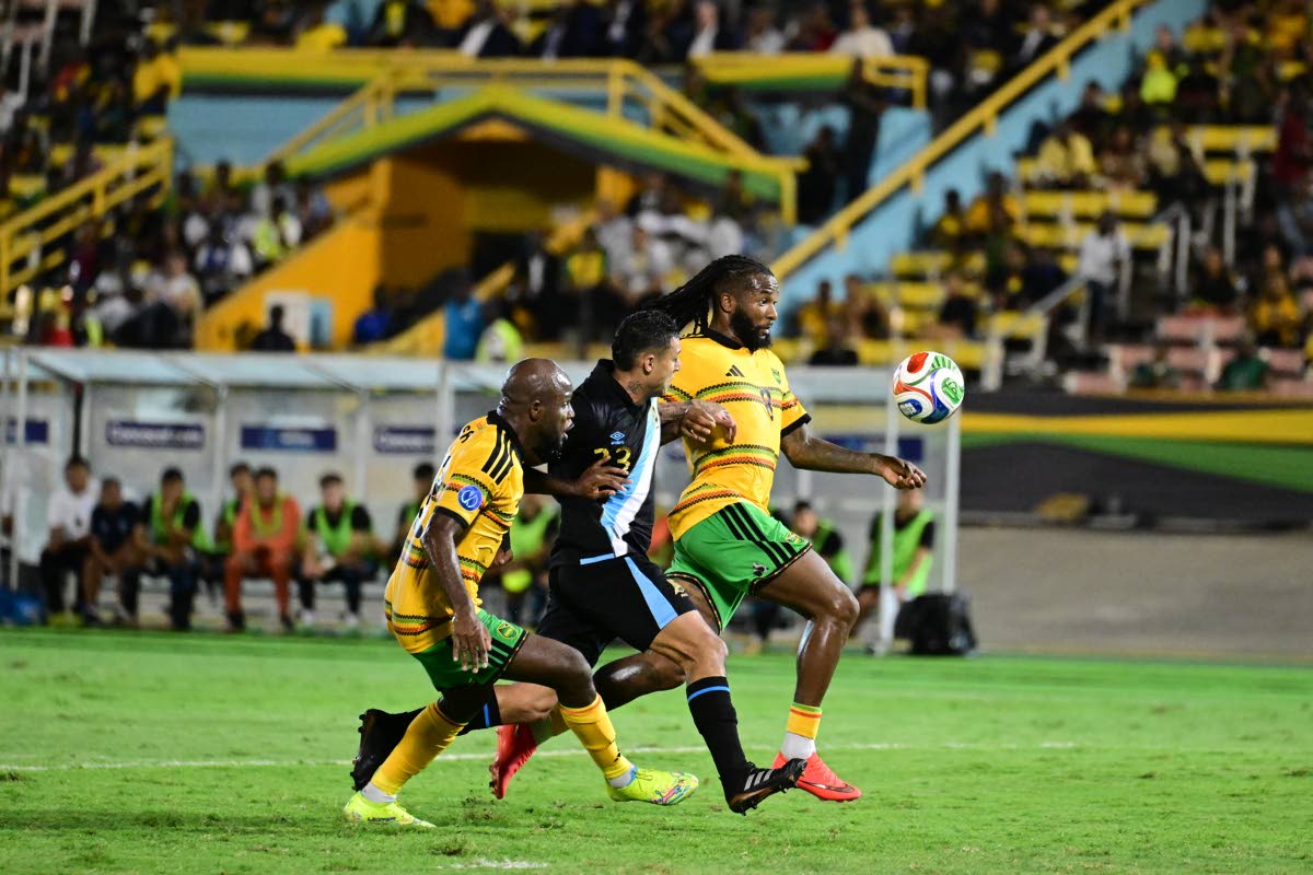 Reggae Boyz Javon East (left) and Kasey Palmer flank Guatemalan midfielder Jorge Aparicio during a Concacaf Nations League encounter at the National Stadium on Friday night.
