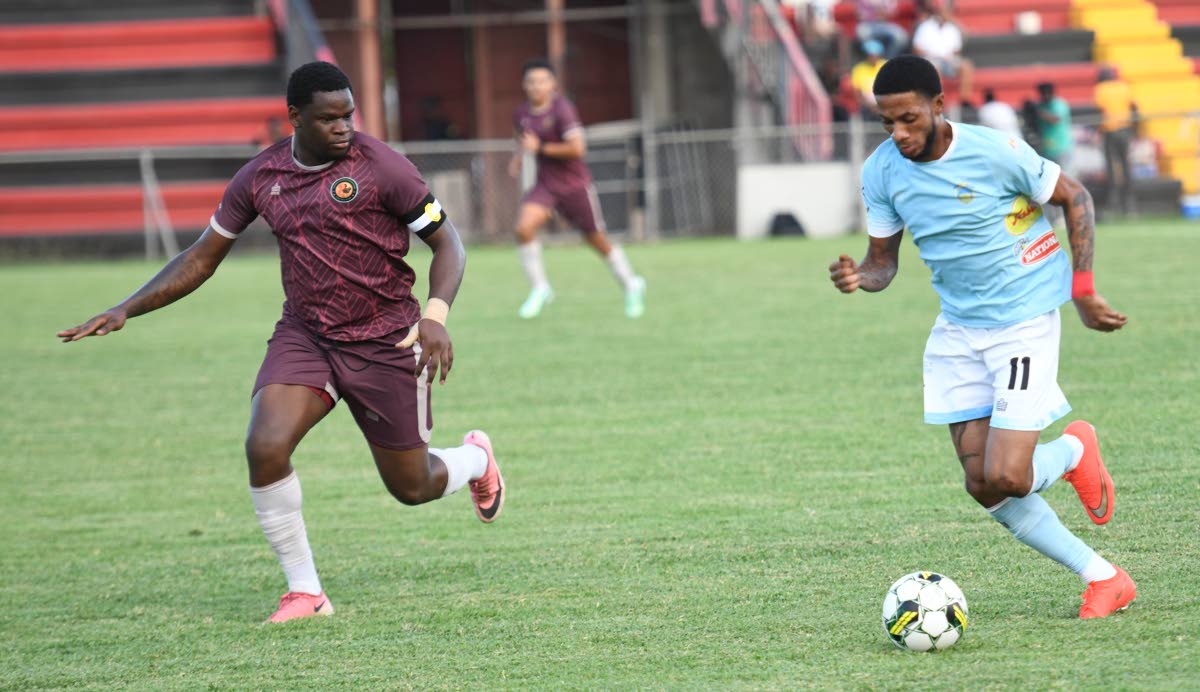 Waterhouse’s Rohan Brown (right) tries to dribble past Chapelton Maroons’ Donhue Mitchell during a Jamaica Premier League football game at the Anthony Spaulding Sports Complex yesterday. 