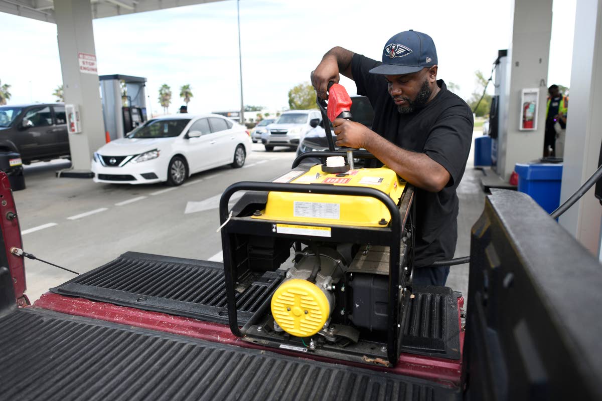 Residents fill up their gas tanks and generators at the Costco Wholesale Gas Station ahead of Hurricane Isaias' expected landfall along the Gulf Coast, Thursday, Oct. 8, 2026, in Mobile, Ala. (AP Photo/Octavio Jones)