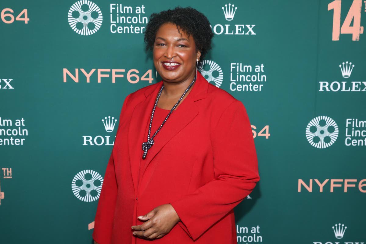 Stacey Abrams brings vibrant colour to the red carpet, accessorising with a metallic necklace.