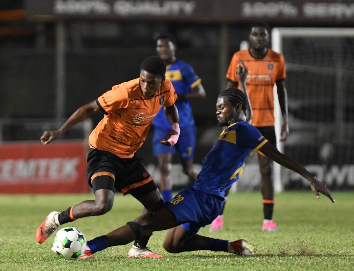 Racing United’s Damion Herrera (right) tackles Tivoli Gardens’ Dwayne Atkinson during a Jamaica Premier League football match at the Waterhouse Stadium yesterday. Racing won the game 4-3.