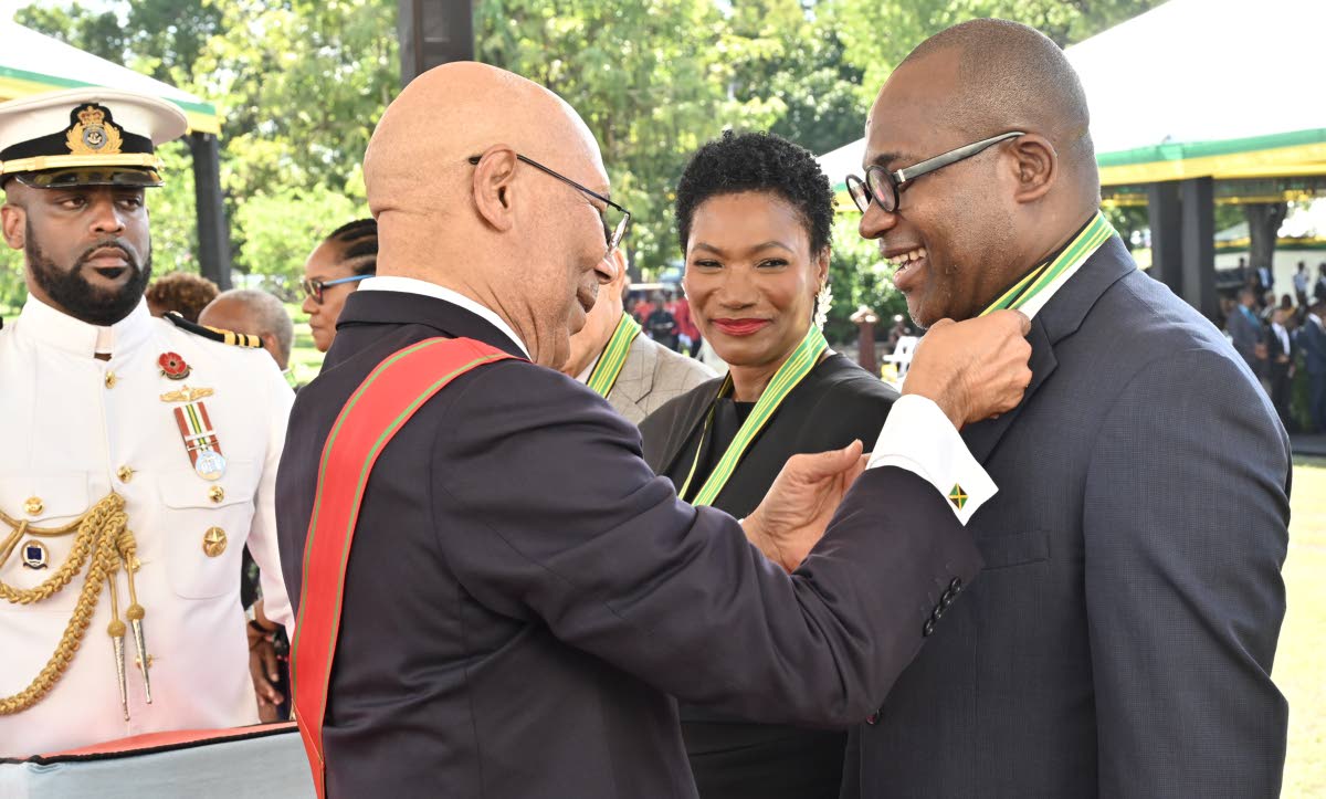 Governor-General Sir Patrick Allen pins the insignia of the Order of Distinction in the Rank of Commander on Professor Densil Williams at the National Honours and Awards Ceremony 2026 at King’s House on Monday. At centre is fellow awardee Audrey Tugwell 