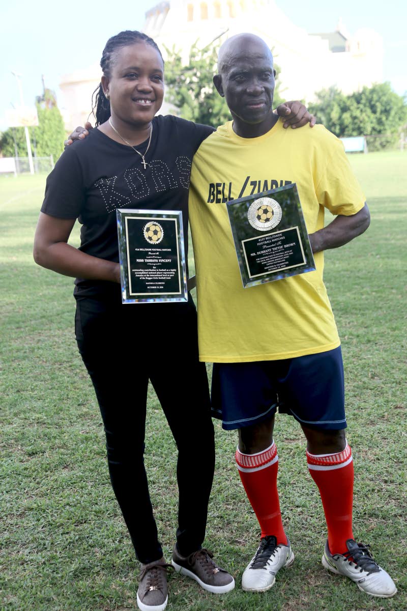 Former national players Tashana Vincent (left) and Durrant ‘Tatti’ Brown display their honorary plaques at the Bell/Ziadie Memorial Football Festival at Winchester Park, St George’s College on Monday.