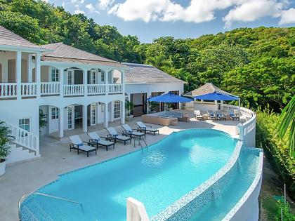 A 10-bedroom, 13-bathroom mansion set on a steep, heavily wooded hillside.										           
