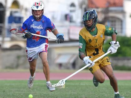 Owen Stephenson (right) of Jamaica, moves clear of  Puerto Rico’s Ryan Stowell during the Pan American Men’s Lacrosse Championship match  at the Stadium East field yesterday.