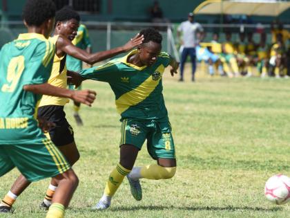 Nichwayne Patrick (right) from Excelsior High School and Jerome McCarthy (centre) from Kingston Technical High compete for the ball during their Ali Cup football match played at Excelsior High School last Thursday.